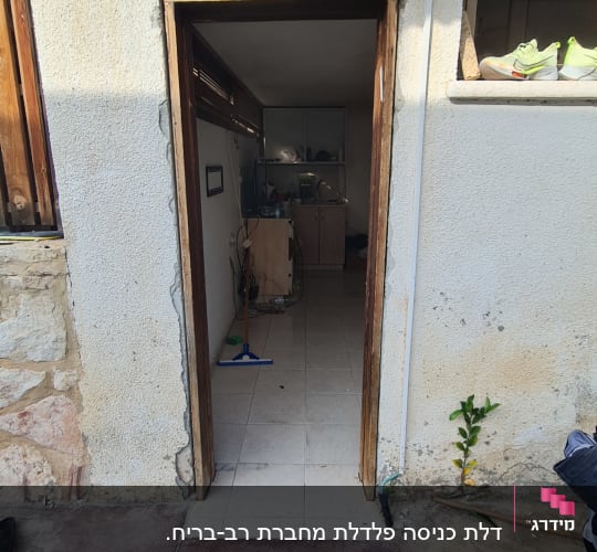 דלת עץ פתוחה עם משקוף חשוף וקיר לבן